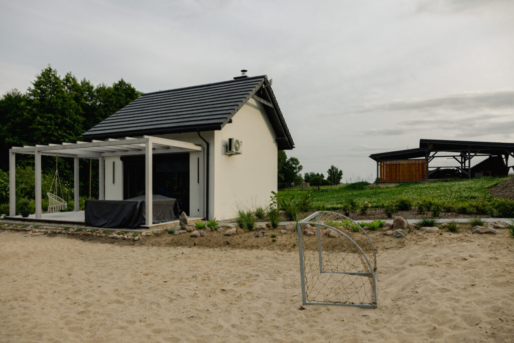 Domek Czapla w Ptasim Siedlisku – biały domek z pergolą i tarasem